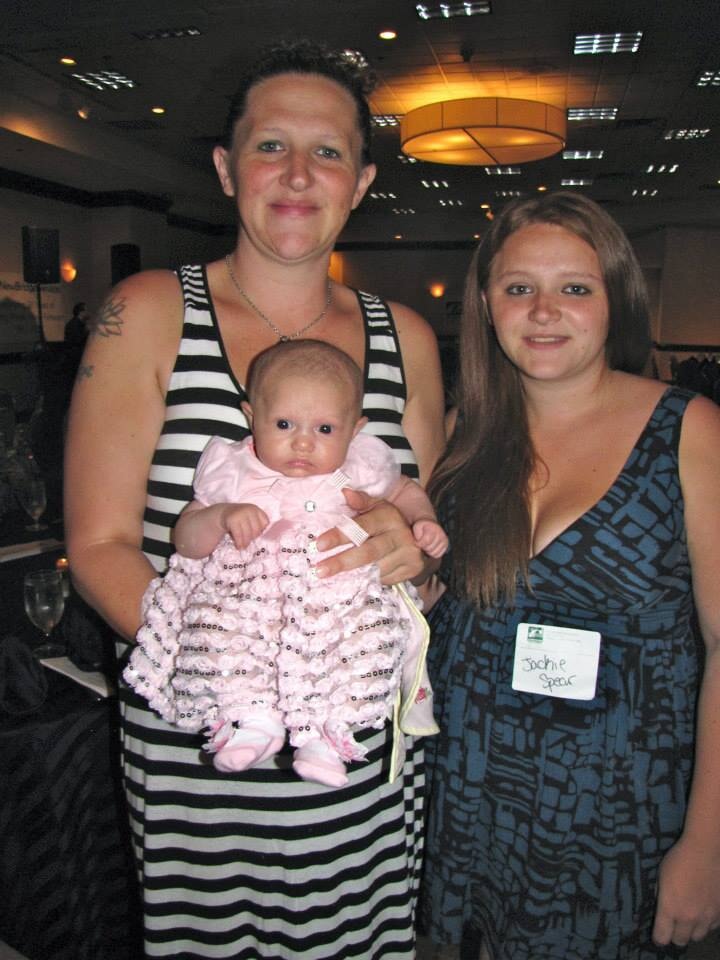 Three generations of women pose for a picture together at a reunion.