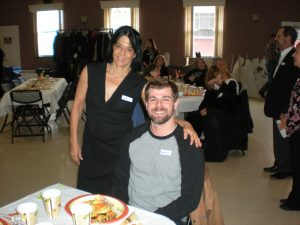 Two people pose at a church Thanksgiving event.