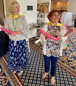 Two smiling women are honored at a NewBridge staff appreciation luncheon for their work.