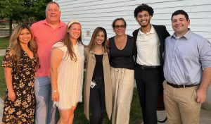 A group of diverse people stand close together and smile.