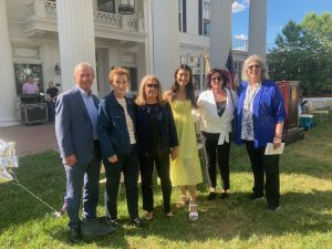 Group photo of seven smiling people outdoors at a graduation. It seems to be Class of 2021.