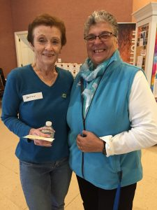 Two smiling women stand side by side at a NewBridge Services Thanksgiving celebration.