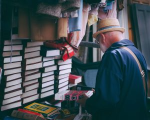 Older man perusing books.