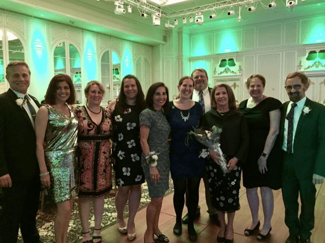 A group of smiling people pose for a photo at a NewBridge event. 