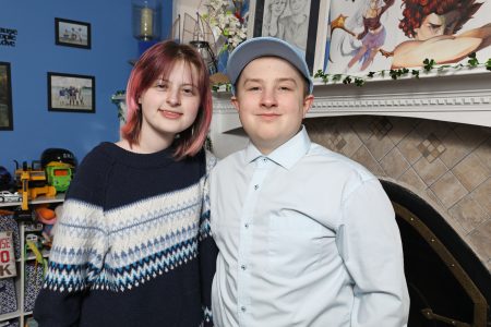  Madyson posing with her twin brother, Matthew, who is wearing a ball cap.